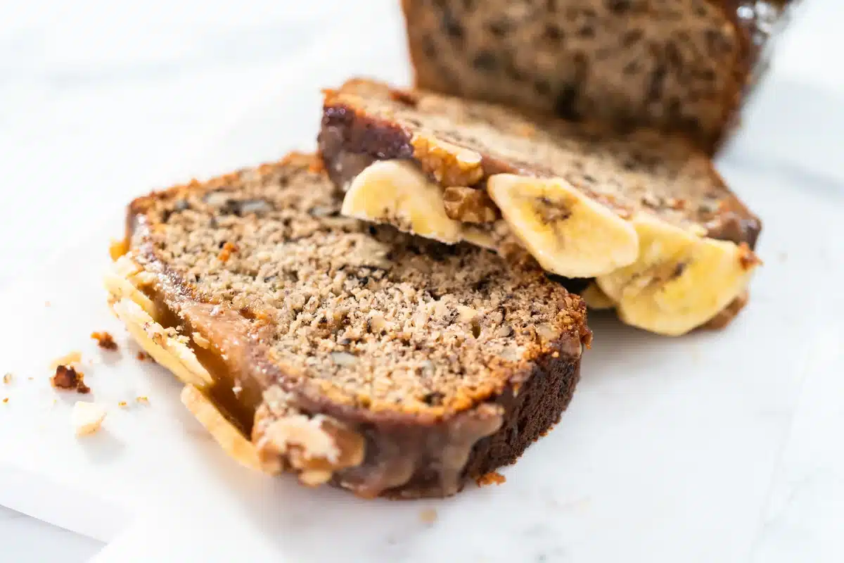 A slice of old fashioned banana nut bread on a plate.